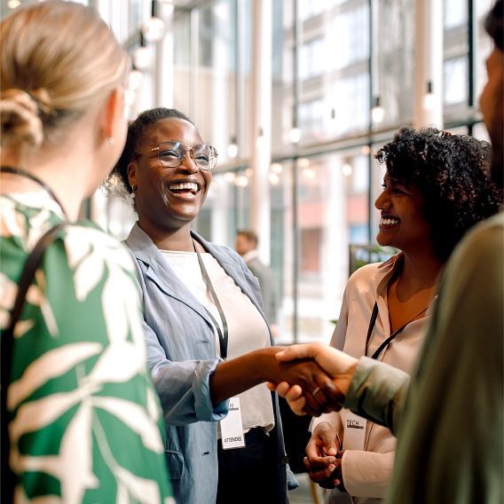 Two people shaking hands at a networking event.